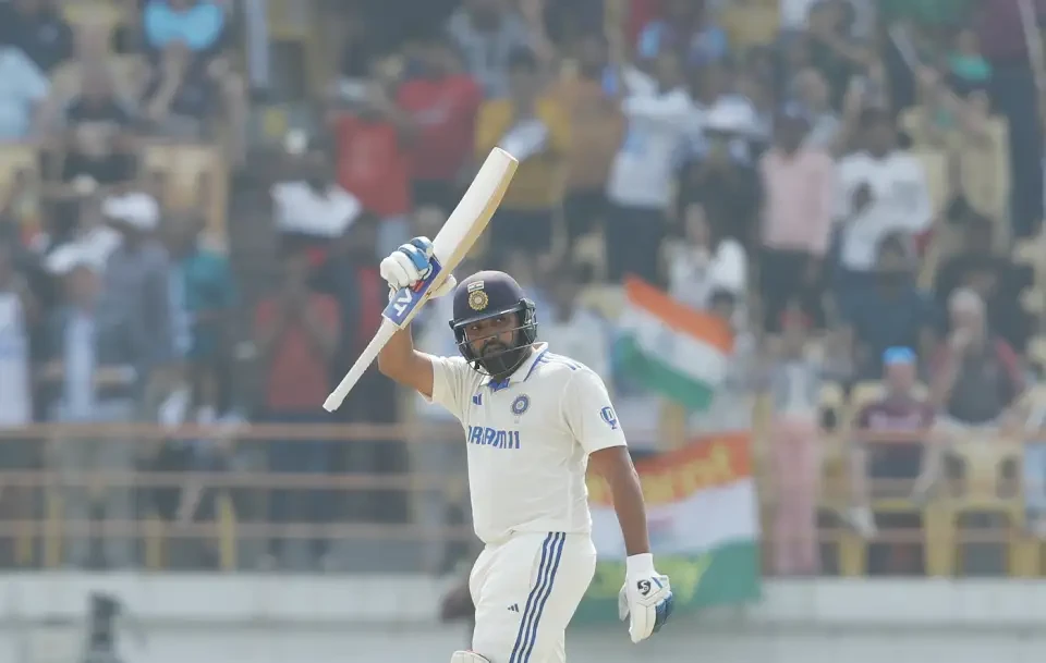 Rohit Sharma raises his bat after scorin a hundred.