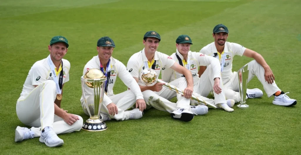Josh Hazlewood, David Warner, Pat Cummins, Steve Smith, Mitchell Starc with the 2015 ODI World Cup, 2021 T20 World Cup, and 2023 World Test Championship Mace.