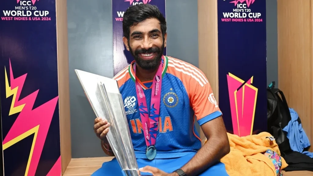 Jasprit Bumrah takes a photo with the ICC Men's T20 Cricket World Cup Trophy.