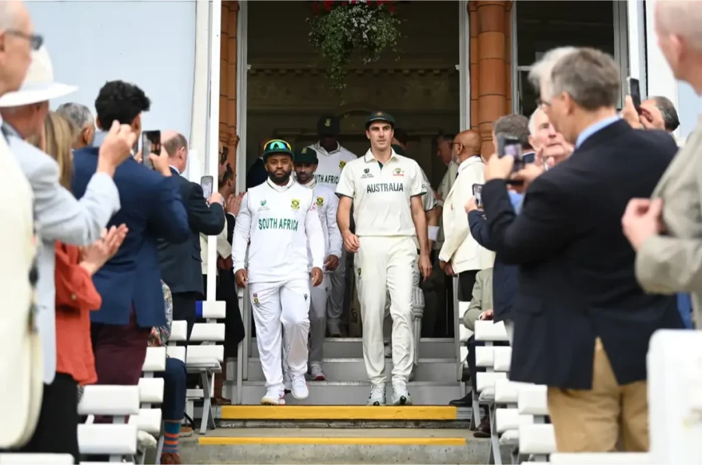 Temba Bavuma and Pat Cummins walk out with their players.