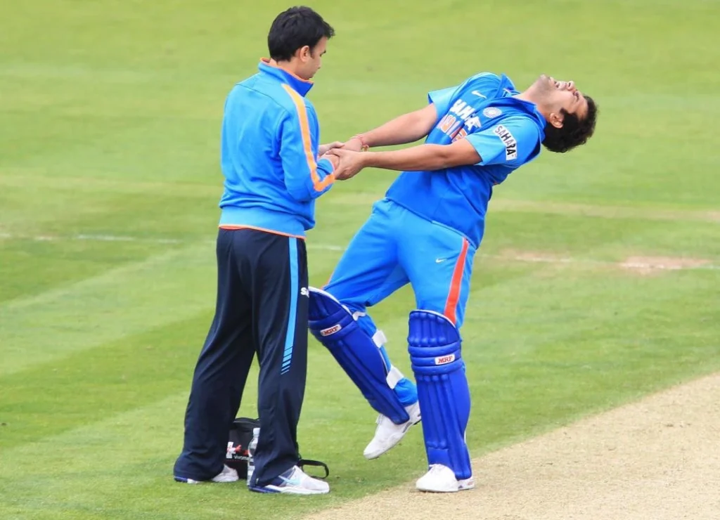 Rohit Sharma screams in pain as the team's physiotherapist treats him.