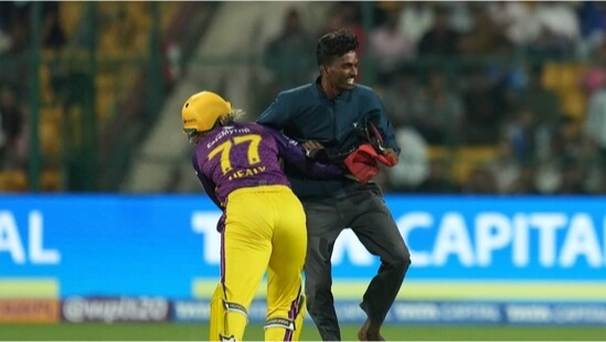 Alyssa Healy tries to tackle the pitch invader.