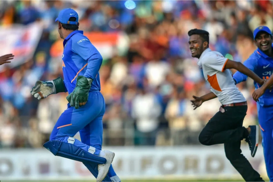 MS Dhoni runs as his fan chases him down for a meet.